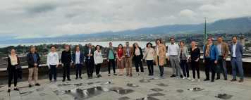 Apéro attendees standing on terrace with view of Zurich in background